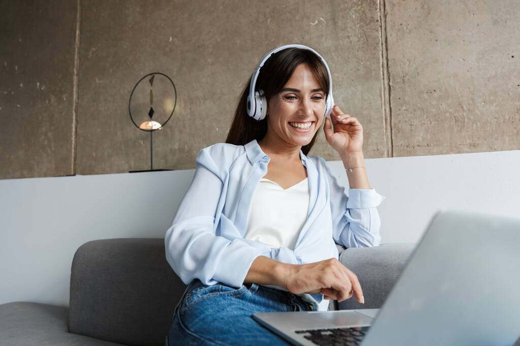 Nő otthon hallgat zenét fejhallgatóval - Fotó, kép