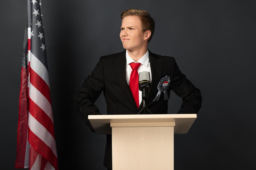homme émotionnel souriant sur tribune avec drapeau américain sur fond noir
 - Photo, image