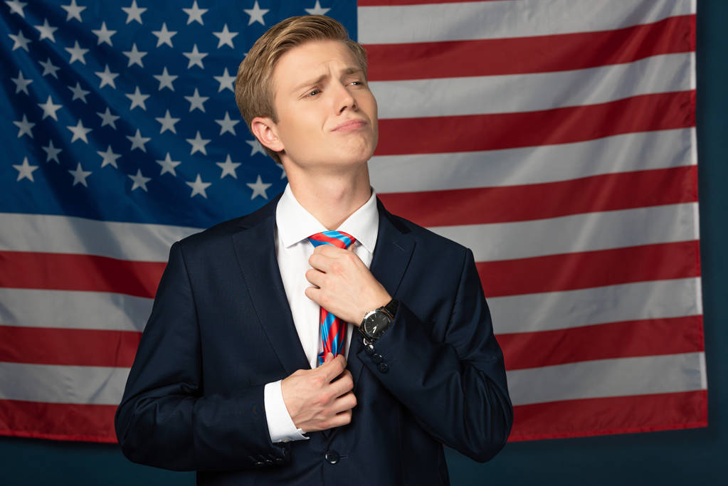Amerikan bayrağı geçmişinde kravat düzelten adam. - Fotoğraf, Görsel