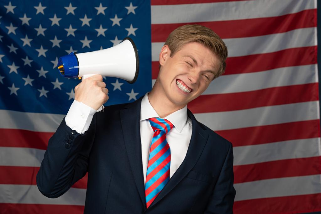 man schreeuwen in megafoon op Amerikaanse vlag achtergrond - Foto, afbeelding