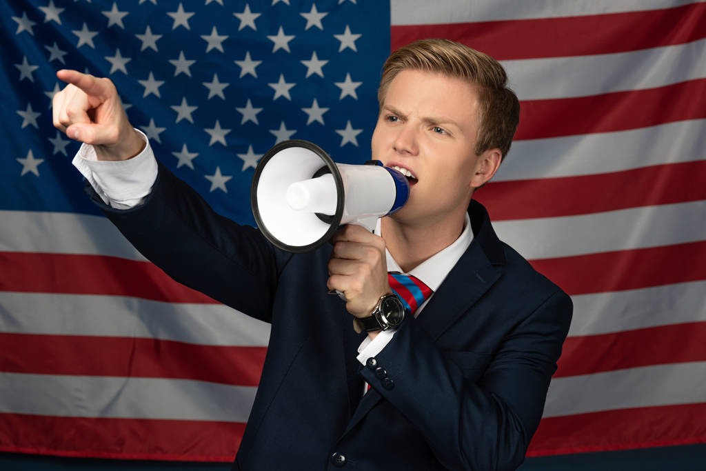 homem gritando em megafone no fundo bandeira americana
 - Foto, Imagem