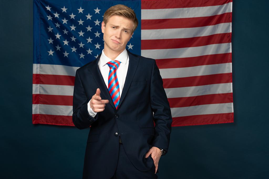 Mann zeigt mit Finger auf Kamera auf Hintergrund amerikanischer Flagge - Foto, Bild
