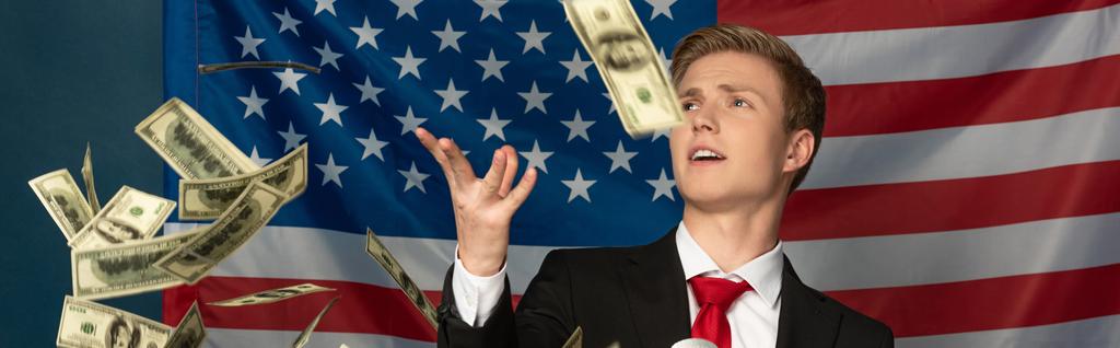 Mann wirft Bargeld auf Tribüne vor Hintergrund amerikanischer Flagge - Foto, Bild