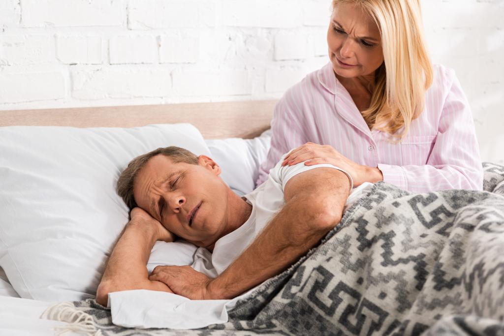 Ανήσυχη γυναίκα ξυπνάει ροχαλίζοντας σύζυγος στο κρεβάτι - Φωτογραφία, εικόνα