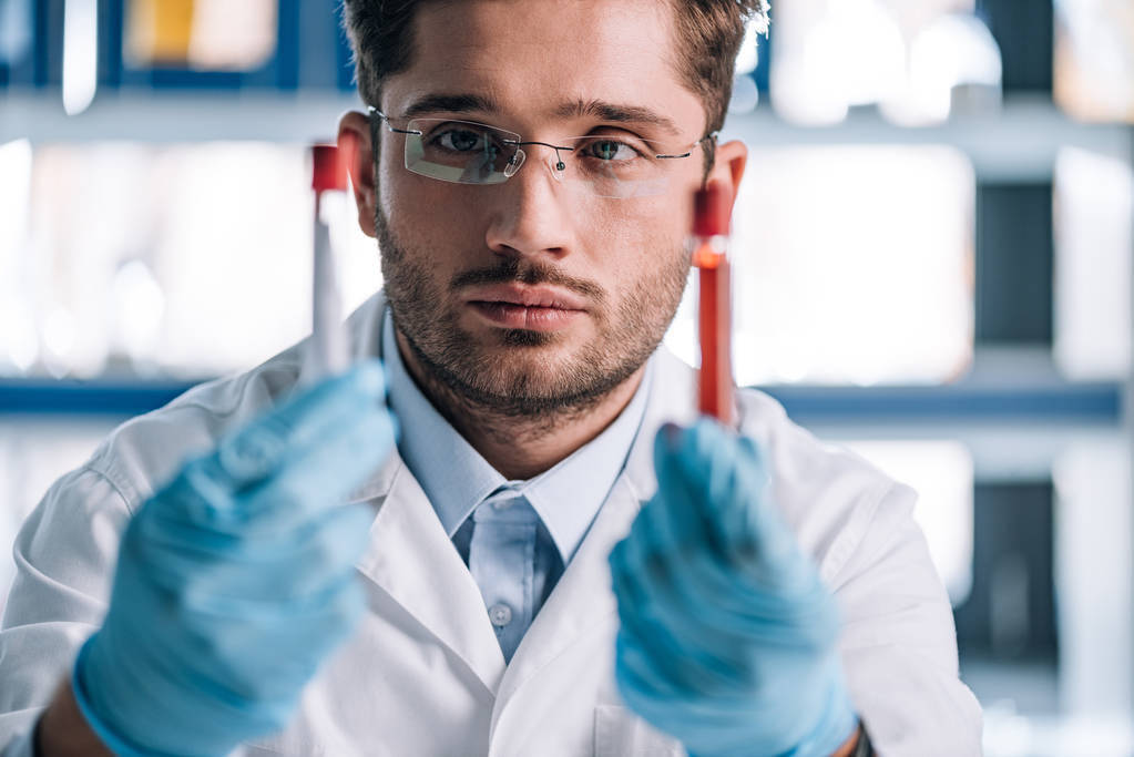 selective focus of handsome immunologist holding test tubes - Photo, Image
