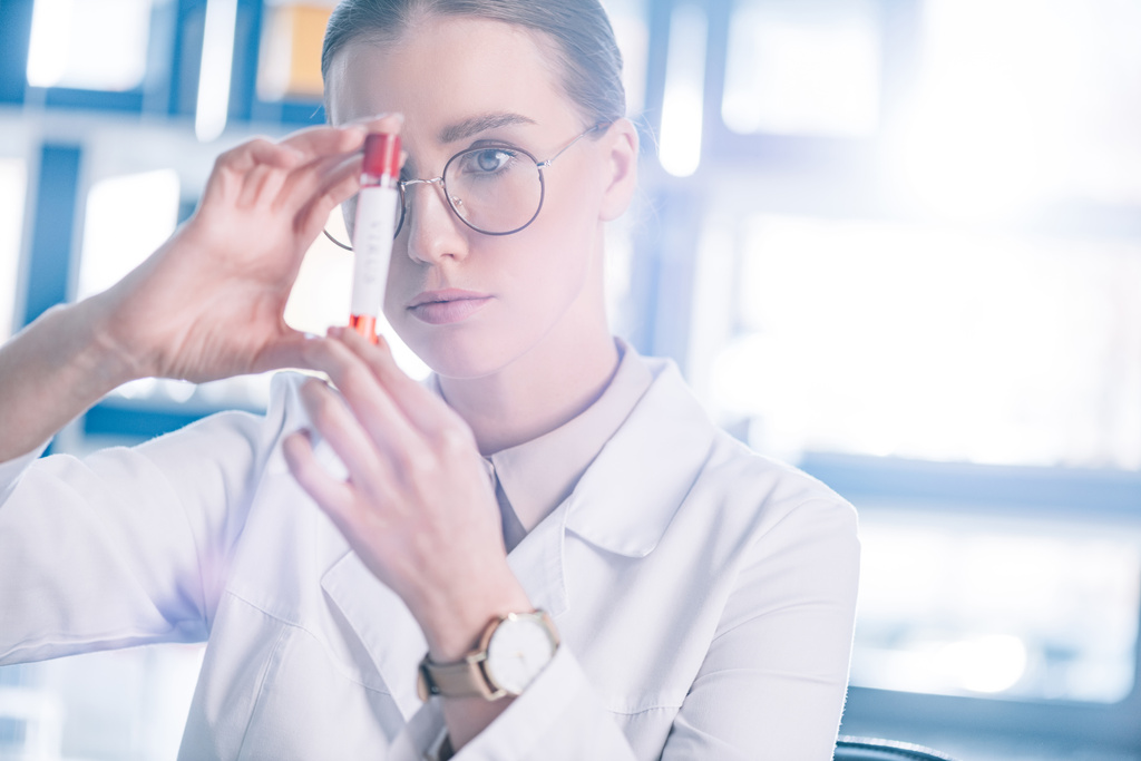 foco seletivo de belo imunologista em óculos segurando tubo de teste
  - Foto, Imagem