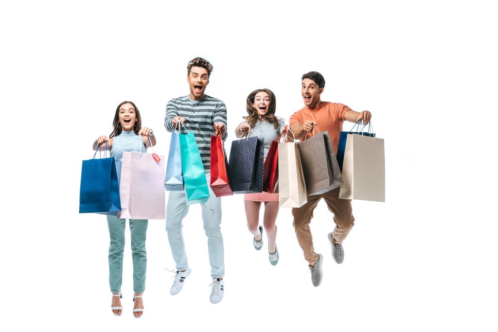 amigos animados pulando e segurando sacos de compras com sinais de venda, isolados em branco
 - Foto, Imagem
