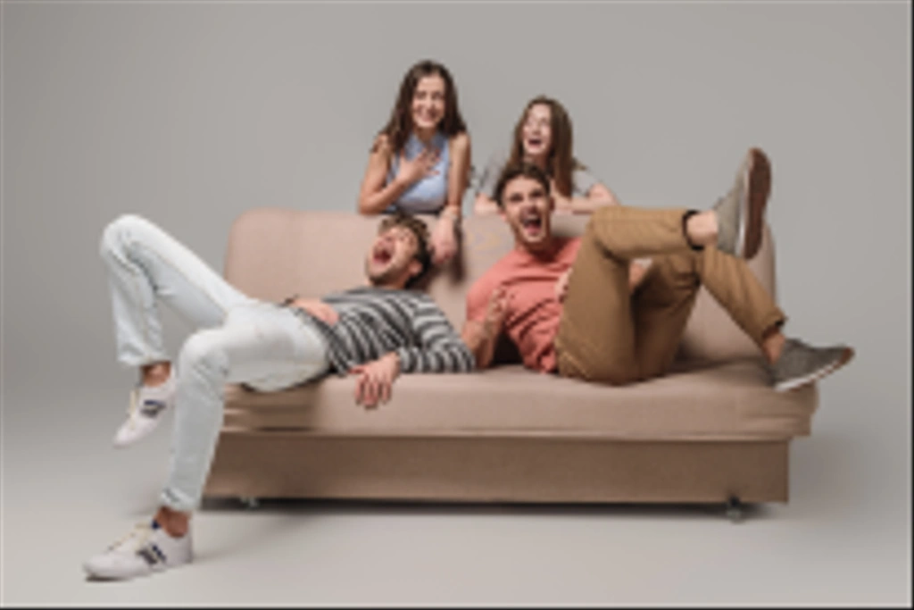 amis heureux riant et relaxant sur canapé sur gris
  - Photo, image