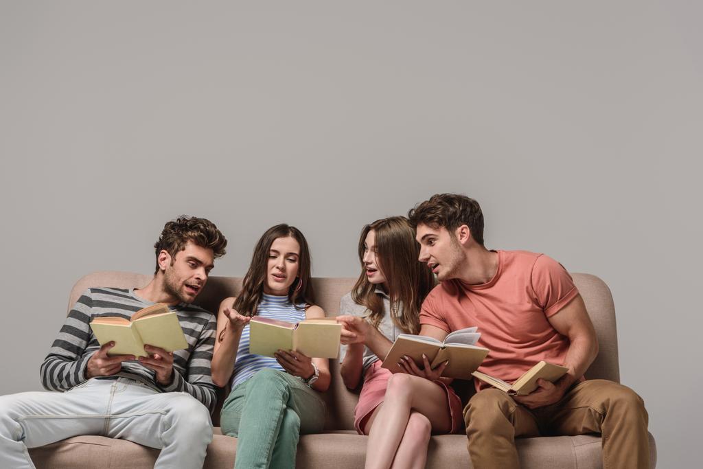 amigos hablando y leyendo libros mientras están sentados en el sofá en gris
 - Foto, Imagen