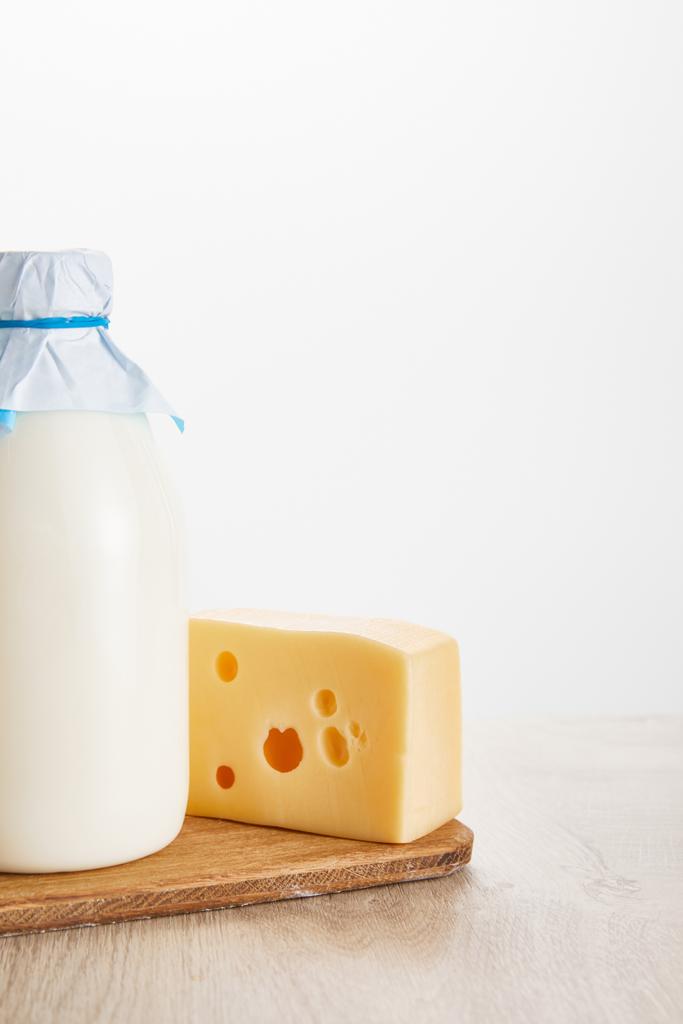 świeże organiczne mleko i ser na drewnianym stole izolowane na białym - Zdjęcie, obraz