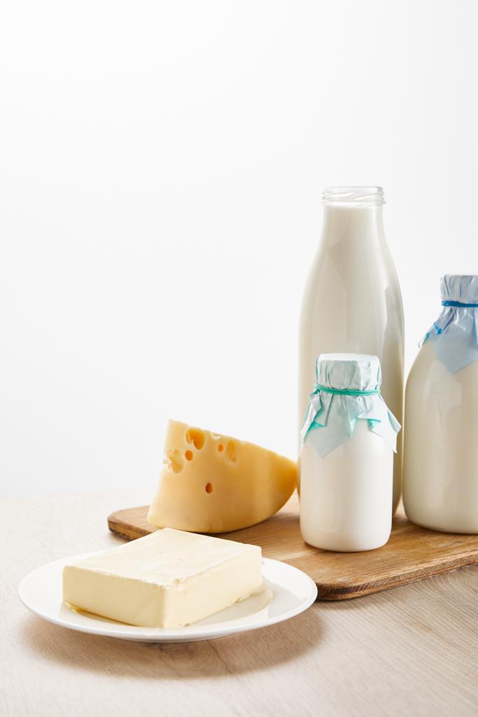 различные свежие органические молочные продукты на деревянной доске изолированы на белом
 - Фото, изображение