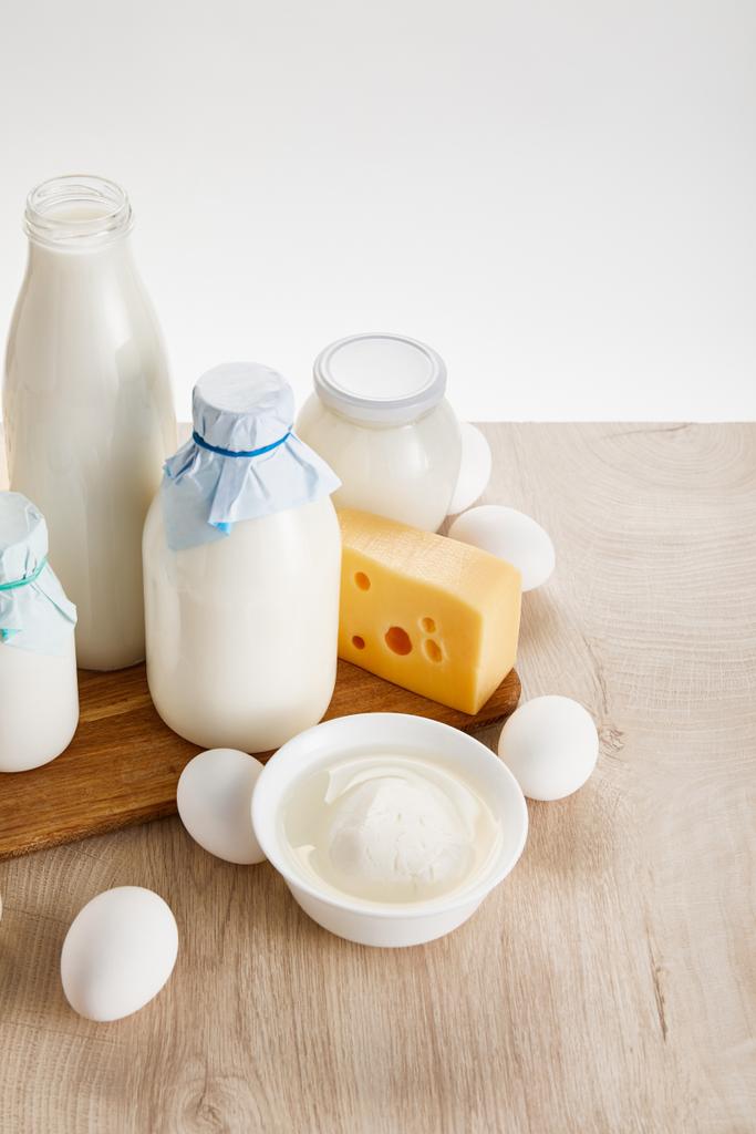 различные свежие органические молочные продукты и яйца на деревянном столе, изолированные на белом
 - Фото, изображение