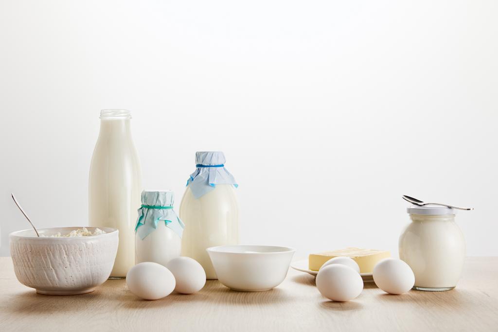 свіжі органічні молочні продукти та яйця на дерев'яному столі ізольовані на білому
 - Фото, зображення