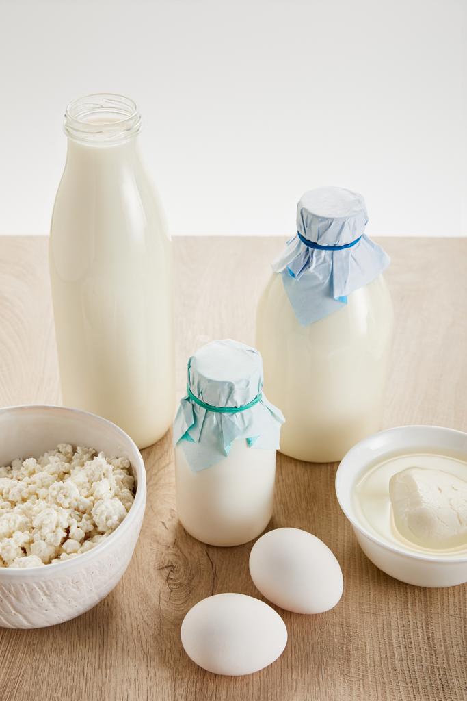 вкусные органические молочные продукты и яйца на деревянном столе, изолированные на белом
 - Фото, изображение