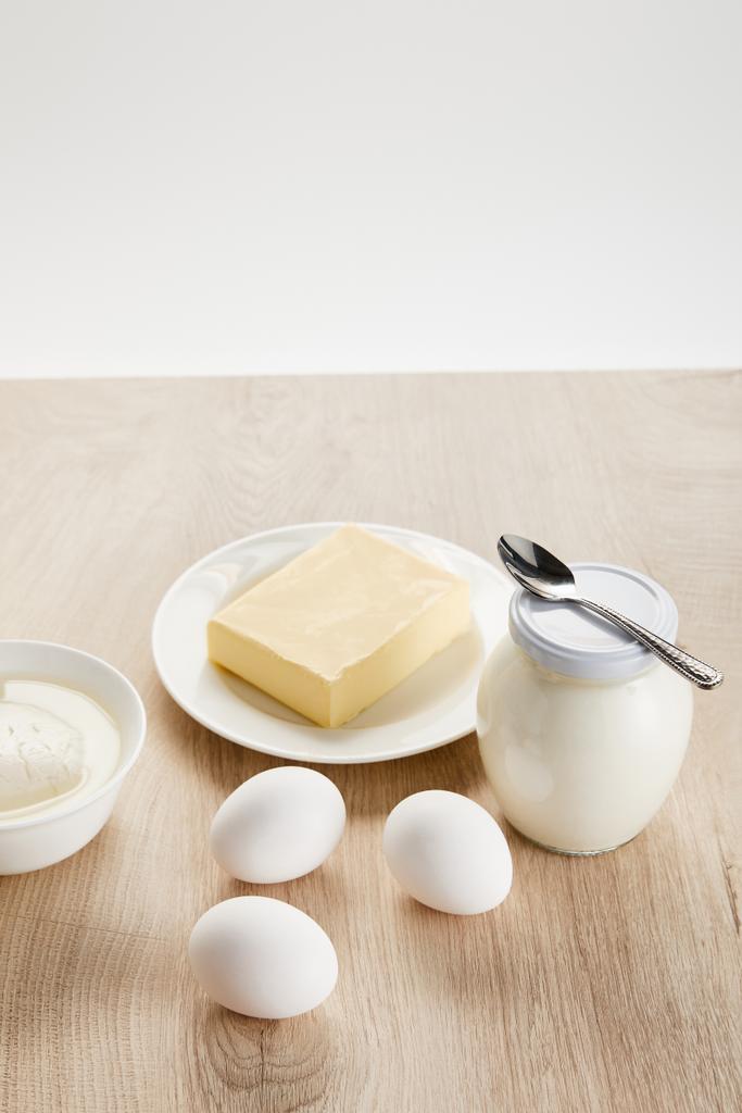 νόστιμα βιολογικά γαλακτοκομικά προϊόντα και αυγά σε ξύλινο τραπέζι που απομονώνονται σε λευκό - Φωτογραφία, εικόνα