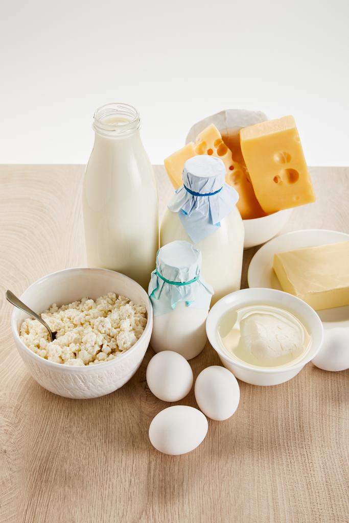вкусные органические молочные продукты и яйца на деревянном столе, изолированные на белом
 - Фото, изображение