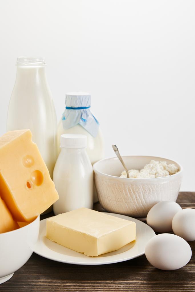 вкусные свежие молочные продукты и яйца на деревянном столе, изолированные на белом
 - Фото, изображение