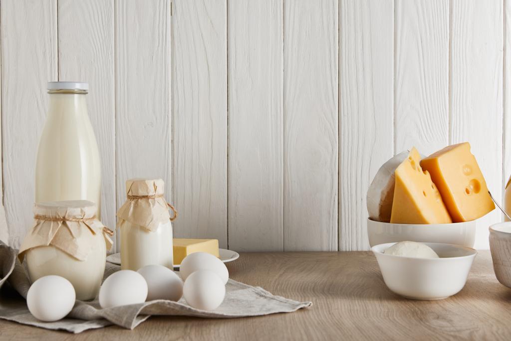 lahodné čerstvé mléčné výrobky a vejce na bílém dřevěném pozadí - Fotografie, Obrázek