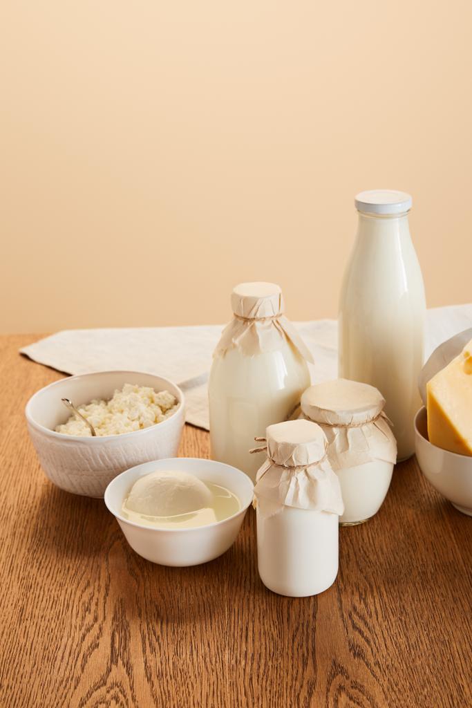 smaczne organiczne produkty mleczne na rustykalnym drewnianym stole izolowane na beżu - Zdjęcie, obraz