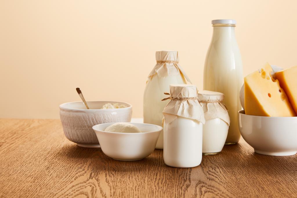 смачні органічні молочні продукти на сільському дерев'яному столі ізольовані на бежевому
 - Фото, зображення