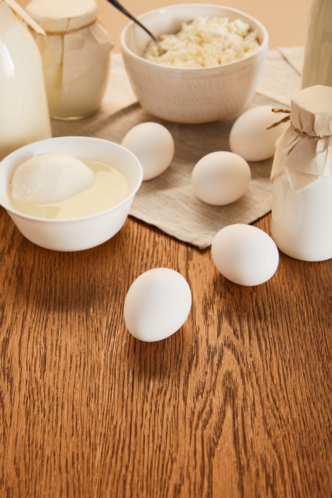 素朴な木のテーブルの上の様々な新鮮な有機乳製品や卵の選択的な焦点 - 写真・画像