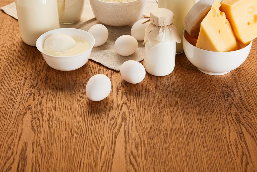 çeşitli organik süt ürünleri ve kırsal ahşap masa üzerinde yumurtalar - Fotoğraf, Görsel