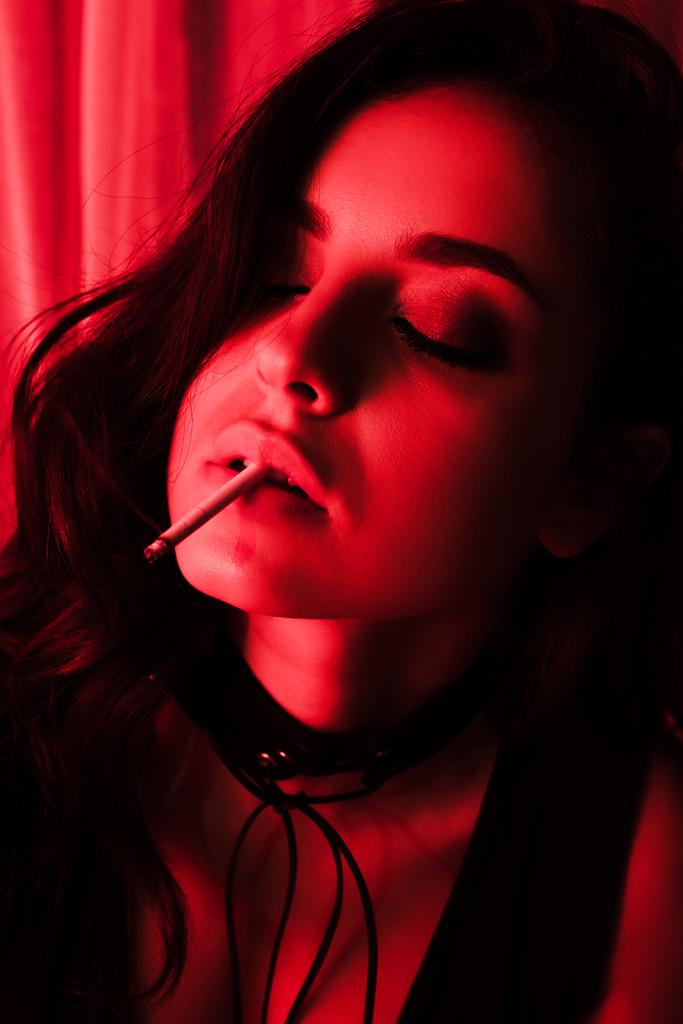 krásná sexy žena kouření cigarety v červeném světle - Fotografie, Obrázek