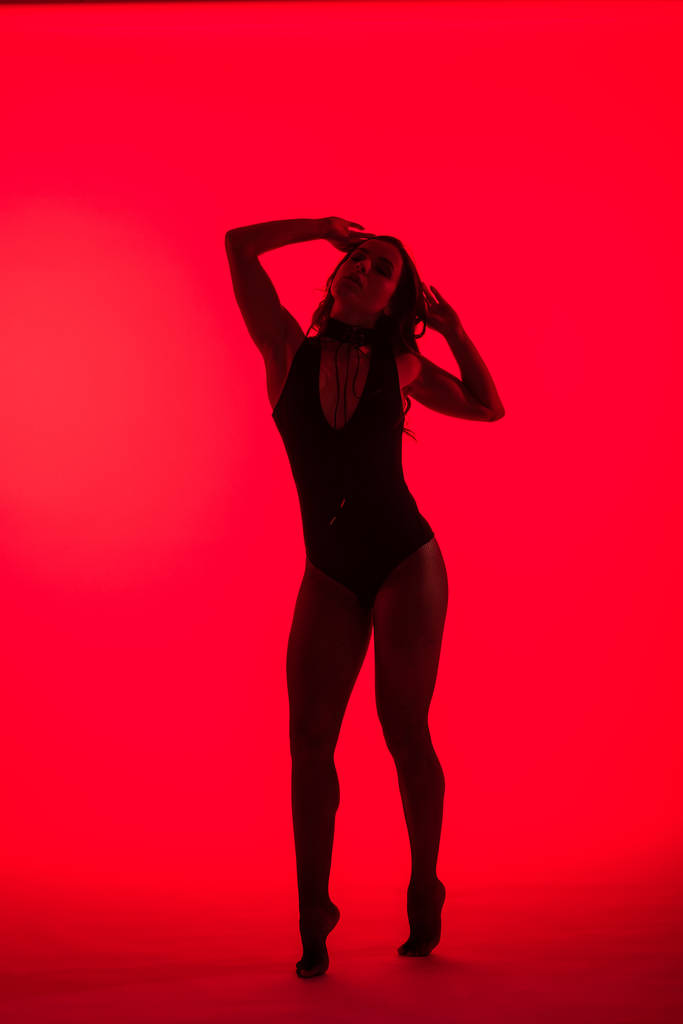 silhouette of attractive sexy young woman, isolated on red - Photo, Image