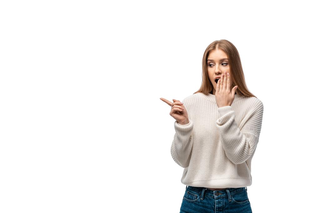 白いセーターを着たショックを受けた若い女性が口を指差して覆い  - 写真・画像