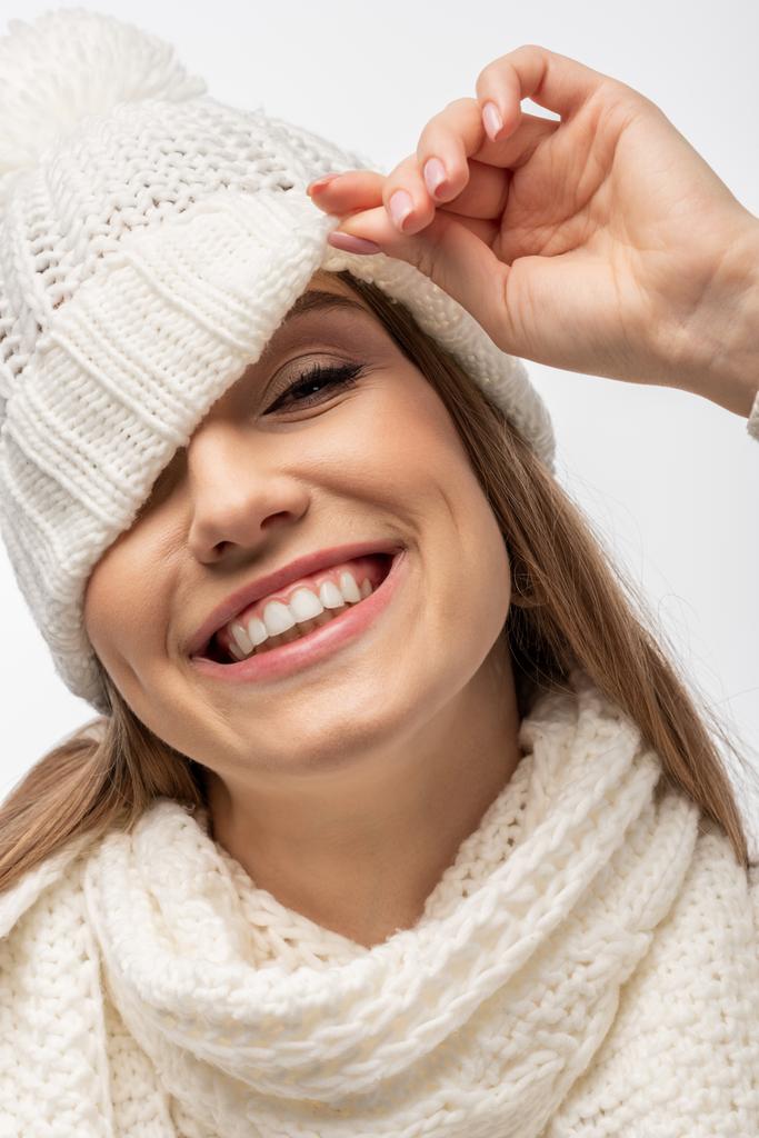 atraktivní veselá dívka v bílém pleteném klobouku při pohledu na kameru, izolované na bílé - Fotografie, Obrázek
