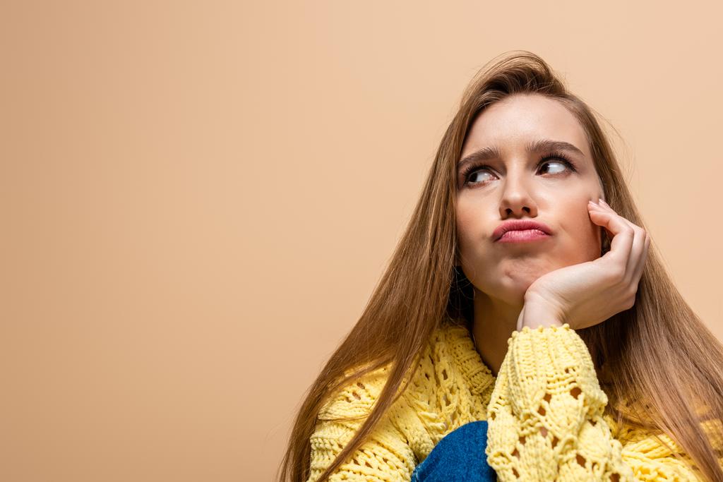 beautiful offended woman in yellow sweater, isolated on beige - Photo, Image