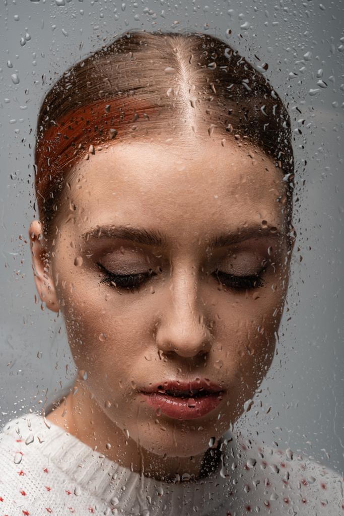 triste donna solitaria su grigio, oltre vetro bagnato con gocce
  - Foto, immagini