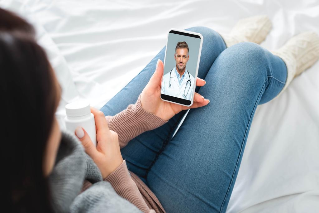 cropped view of sick woman with pills having online consultation with male doctor on smartphone - Photo, Image