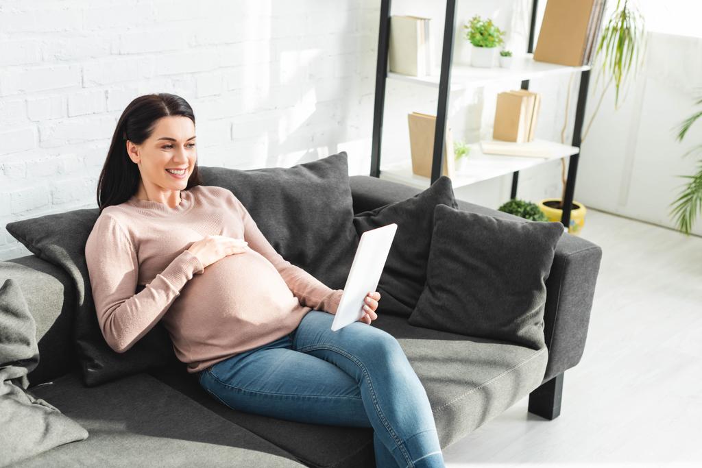 Schwangere mit Online-Beratung beim Arzt auf digitalem Tablet zu Hause - Foto, Bild