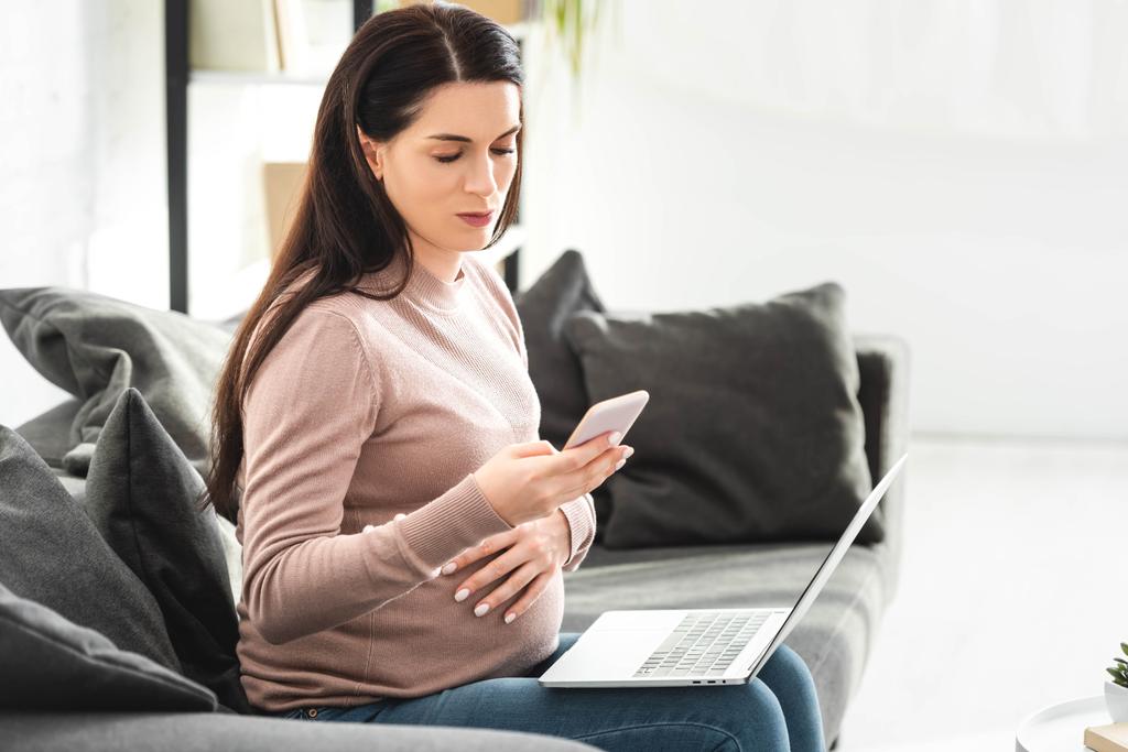 raskaana oleva nainen, jolla on verkossa lääkärin kanssa kannettavan tietokoneen ja älypuhelimen
 - Valokuva, kuva