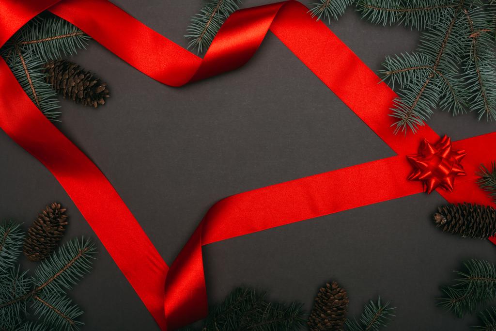 верхний вид рождественской красной ленты и елочных ветвей на черный
 - Фото, изображение
