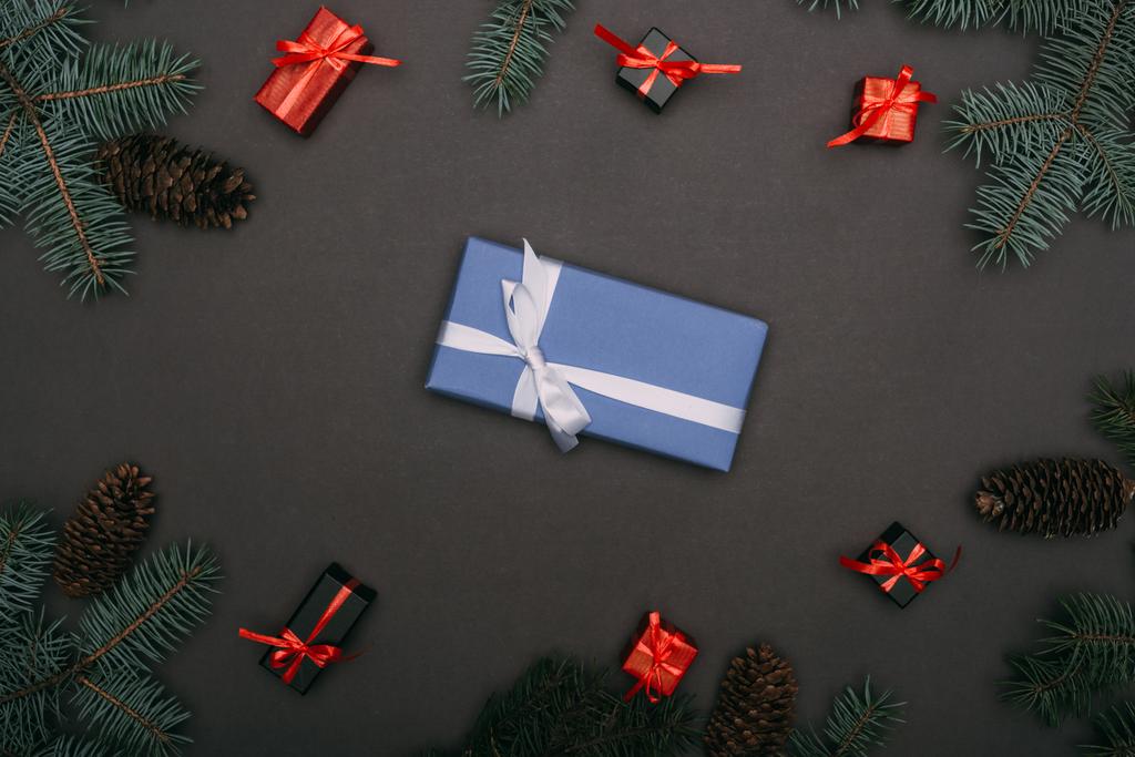 vista superior de las cajas de regalo de Navidad con ramas de abeto y conos de pino en negro
 - Foto, imagen