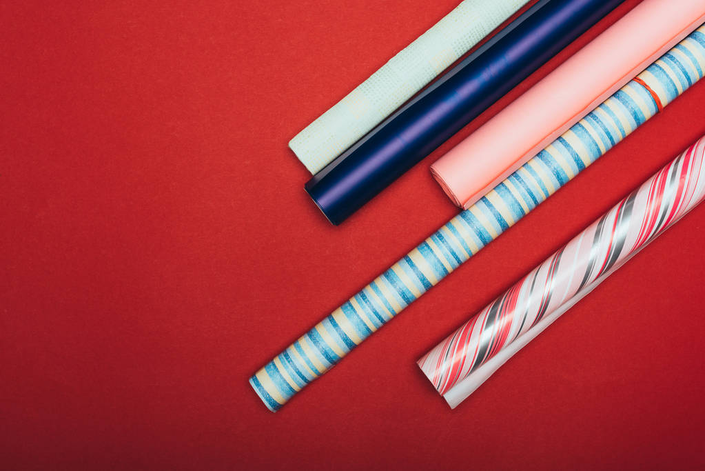 top view of wrapping paper rolls on red - 写真・画像