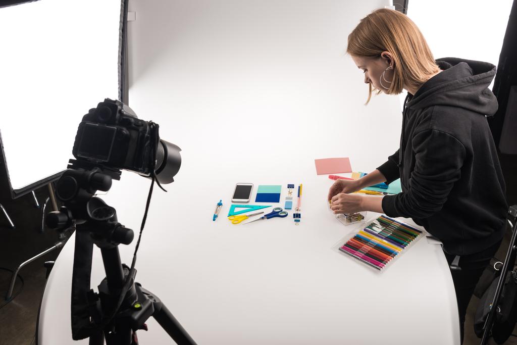 photographer making flat lay with office supplies for commercial photo shooting on white - Photo, Image