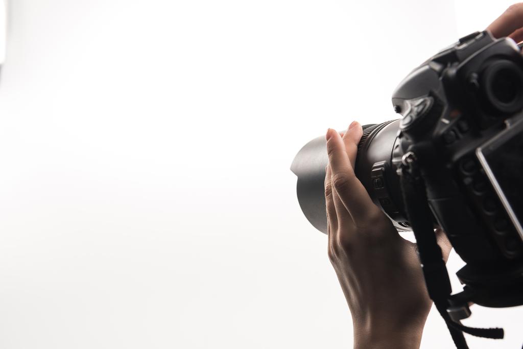 Ausgeschnittene Ansicht des Fotografen, der mit Digitalkamera isoliert auf Weiß arbeitet - Foto, Bild