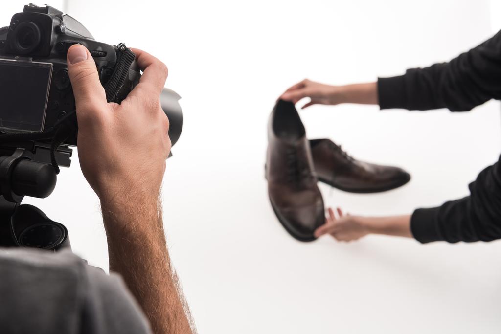 vue recadrée de photographes commerciaux faisant séance photo de chaussures masculines sur blanc
 - Photo, image