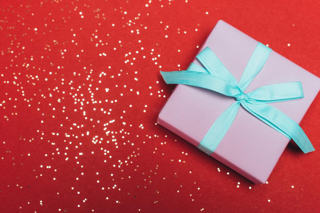 vista superior de un regalo de Navidad con confeti dorado sobre rojo
 - Foto, Imagen