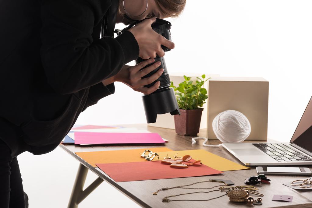 фотограф фотографирует композицию с флорой и аксессуарами для коммерческой фотосъемки с фотоаппаратом и ноутбуком
 - Фото, изображение