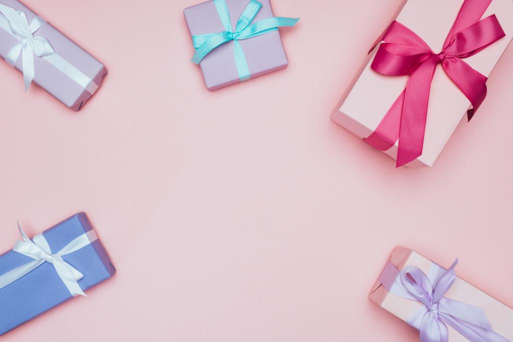 вид зверху різдвяні подарункові коробки зі стрічками та бантами, ізольовані на рожевому
 - Фото, зображення