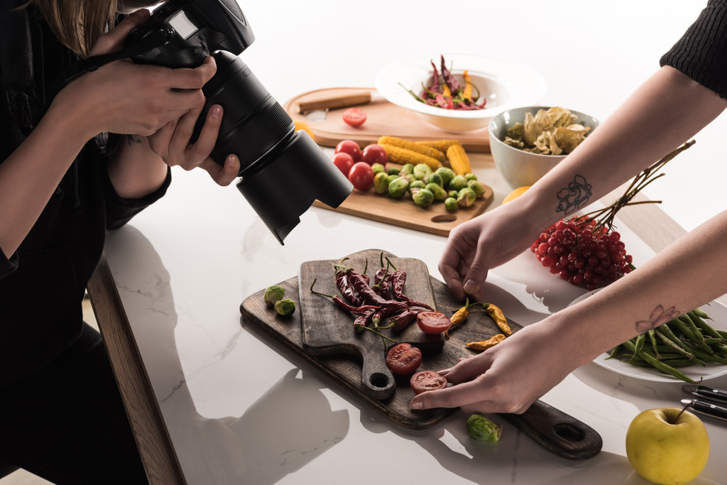 abgeschnittene Ansicht kommerzieller Fotografen, die Fotoshooting von Lebensmitteln auf Digitalkamera machen - Foto, Bild