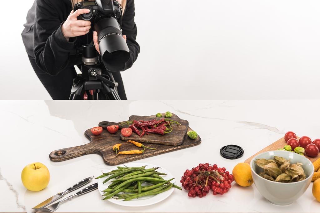 vista recortada de fotógrafa haciendo composición de alimentos para fotografía comercial y tomando fotos en cámara digital
  - Foto, imagen