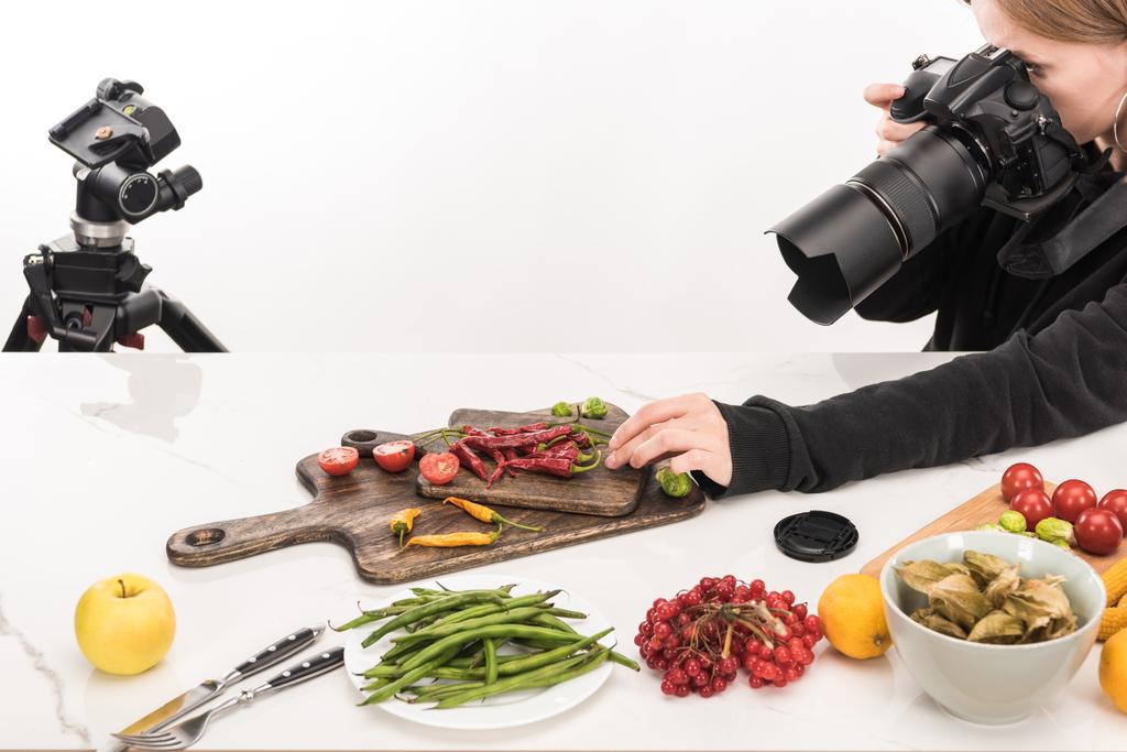 Fotografin komponiert Nahrungsmittel für kommerzielle Fotografie und fotografiert mit Digitalkamera  - Foto, Bild