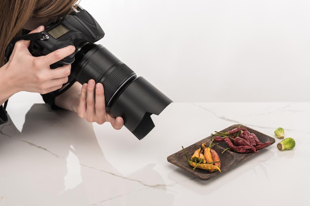 vista ritagliata di fotografo femminile fare composizione alimentare per la fotografia commerciale e scattare foto sulla fotocamera digitale su bianco
 - Foto, immagini