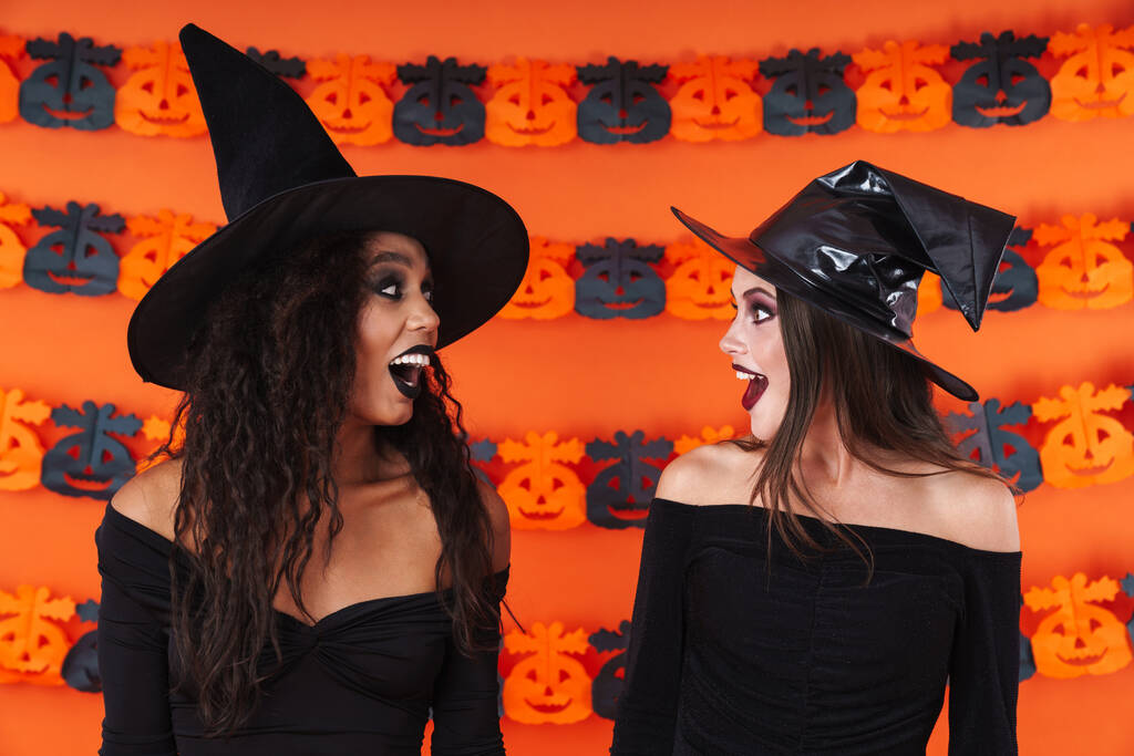 Bild von Hexenfrauen in schwarzem Halloween-Kostüm, die sich gegenseitig anschauen  - Foto, Bild