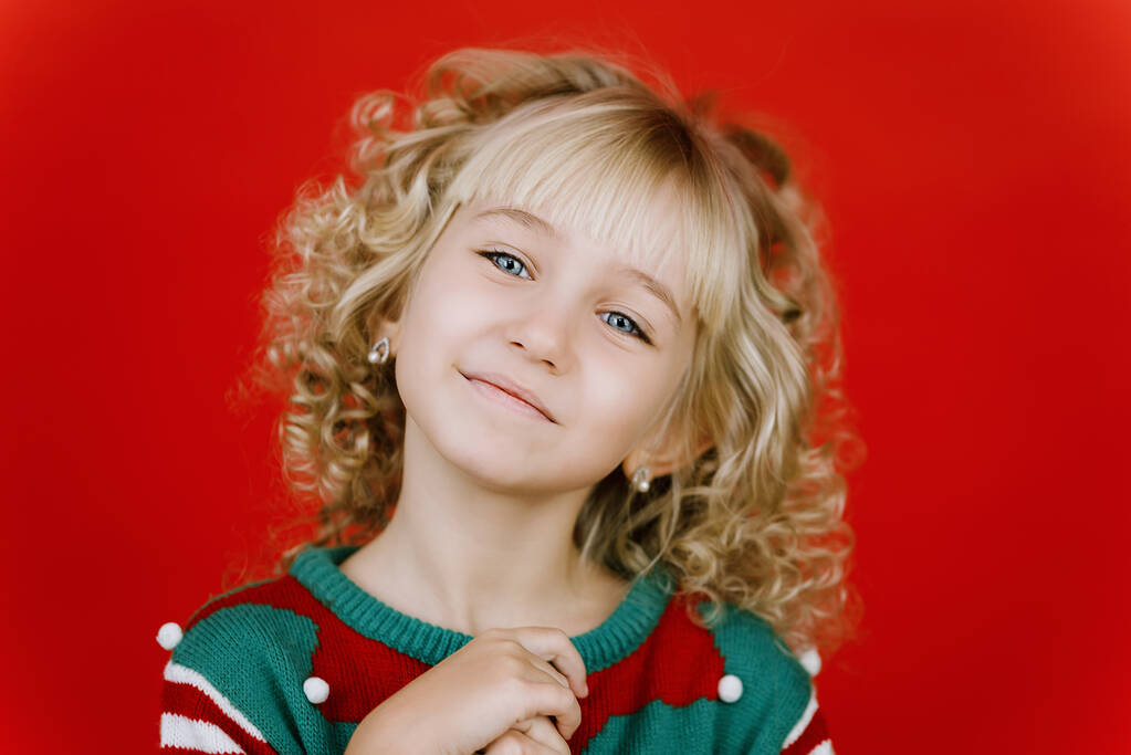 Little girl in Santa elf helper costume on bright red vivid color background. - Photo, Image